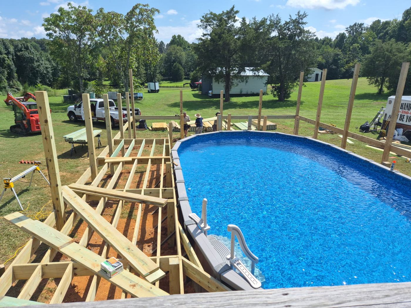 Deck framing and support posts going in around an above ground pool in a large Alamance County back yard