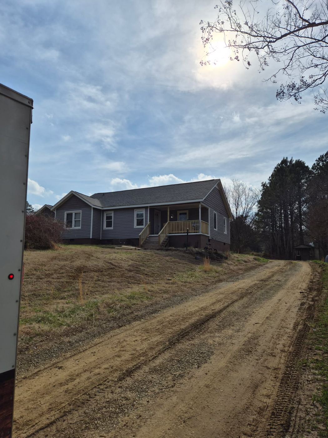 Ranch home in Alamance County NC finished with new grey siding, white trimmed windows and a rebuilt front porch
